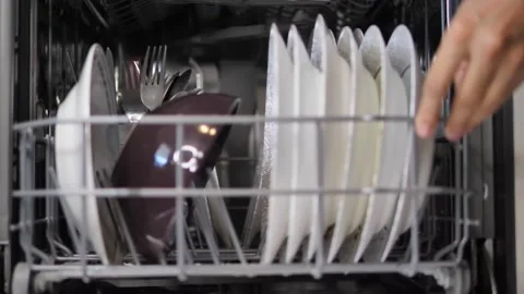 Adding dishes into the dishwasher machine Stock Footage 169769830
