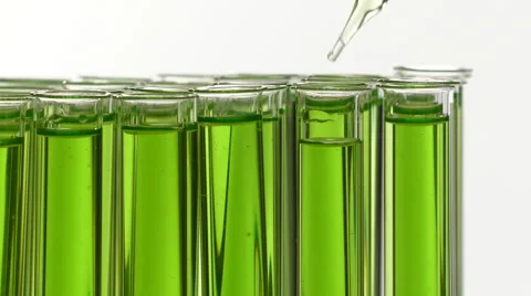 Adding drops of liquid in a test tube filled with green liquid Stock-Footage 64290495