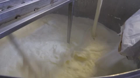 Adding Dry Ingredients To Milk Cream And Stirring In A Large Metal Boiler Stock Footage 246686796