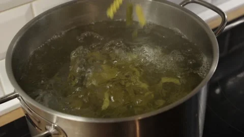 Adding dry two colors Italian pasta into boiling water in stainless steel pot 스톡 동영상 332826777