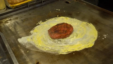 Adding egg and cheese to beef and chicken patty Stock Footage 94581318