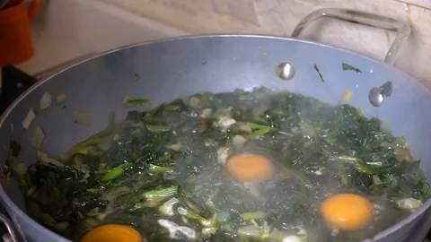 Adding Egg on Cooking Spinach Stock Footage 104892231
