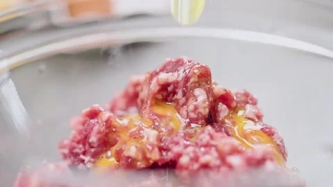 Adding egg to the minced meat. Stock Footage 150884490