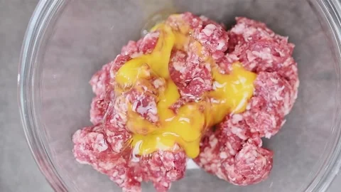 Adding egg to the minced meat. Video stock 150884542