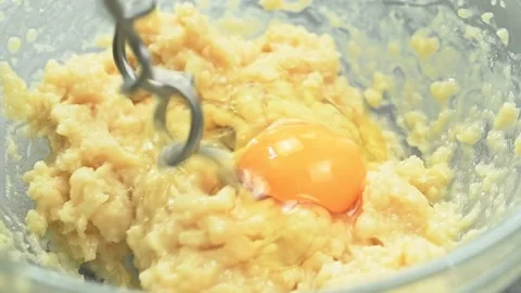 Adding egg to the mixture. Process of making dough for donuts. Stock Footage 169799935