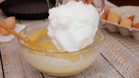 Adding the egg-white whip to the other sponge-cake ingredients Stock Footage 105718362
