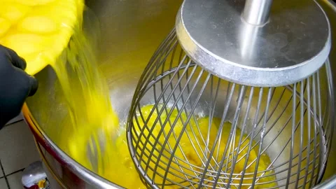 Adding eggs into a big planetary mixer UHD Stock Footage 151919969