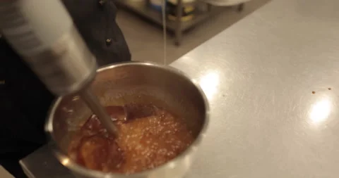 Adding the eggs to the bowl while the immersion blender is running. Stock Footage 256409702