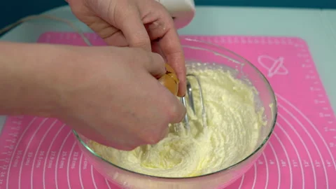 Adding eggs to the cream and whipping with a mixer close-up. Making Valentine's Stock Footage 146869516