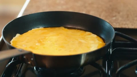 Adding eggs to frying pan to make scrambled eggs 스톡 동영상 260753528