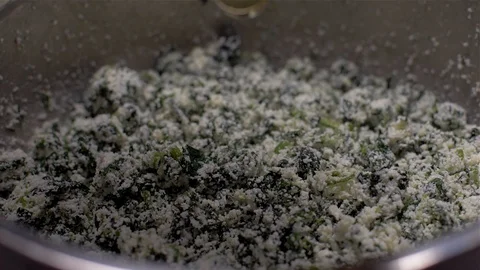Adding eggs to ricotta and spinach Slow Motion Stock Footage 103859611