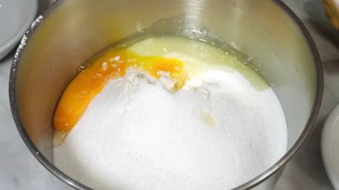 Adding eggs to the sugar for homemade cookie dough preparation Stock Footage 320067455