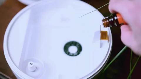 Adding essential oils to a diffuser for a calming aromatherapy Stock Footage 303521744