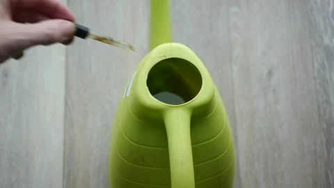 Adding Fertilizer To Watering Can Stock Footage 169666295