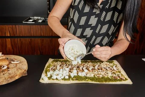Adding feta cubes to pesto base Stock Photos