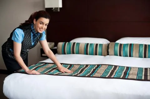 Adding final touches to bedroom before customer arrival Stock Photos