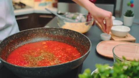 Adding fine salt to tomato sauce Stock Footage 252450468
