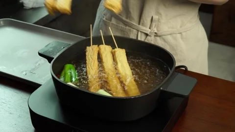Adding Fish Cake Skewers to Boiling Broth Stock Footage 334160093