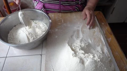 Adding flour to the base for the dough in a metal bowl Stock Photos