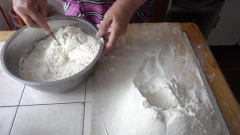 Adding flour to the base for the dough in a metal bowl Stock Photos