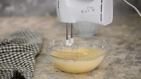 Adding Flour To Batter In Glass Bowl. Mixing cake batter with mixer. Video stock 124713549