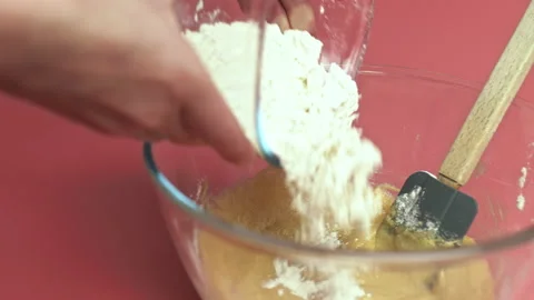 Adding flour to a Chocolate Chip Cookies dough in a glass bowl in 4K. Stock Footage 135699218
