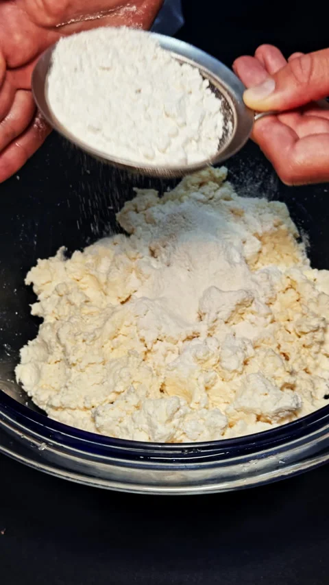 Adding Flour to Cottage Cheese Mixture in Bowl Stock Footage 277731624