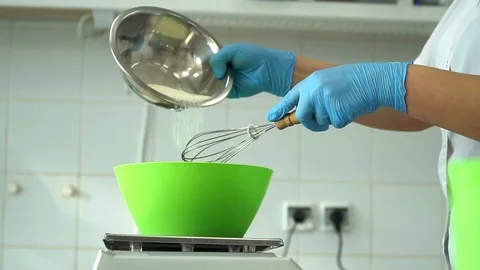 Adding flour to the dough. Chef hands pouring white flour to the dough in bowl. Stock Footage 85666604