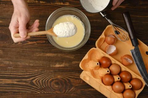 Adding flour to eggs mixed with milk? top view Foto stock