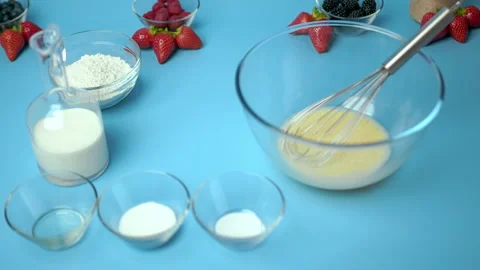 Adding flour, eggs, oil, milk, salt, sugar into a mixing glass bowl. Video stock 133592375