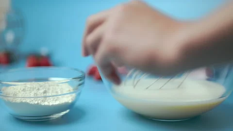 Adding flour, eggs, oil, milk, salt, sugar into a mixing glass bowl. Stock Footage 133595333
