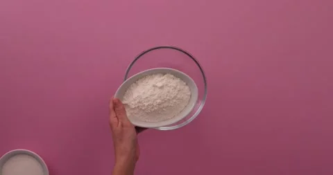 Adding flour to a glass bowl Stock Footage 132208655