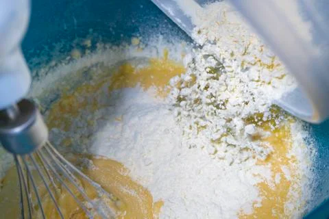Adding flour to mounted egg to make sponge cake. Stock Photos