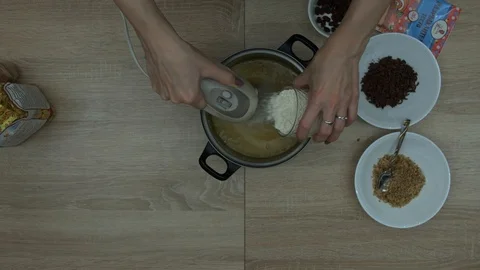 Adding flour to oil mixture in a bowl Stock Footage 87504402