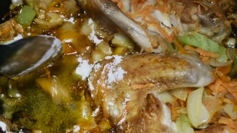 Adding flour to a skillet with chicken wings with chopped vegetables Vídeos de archivo 225241456