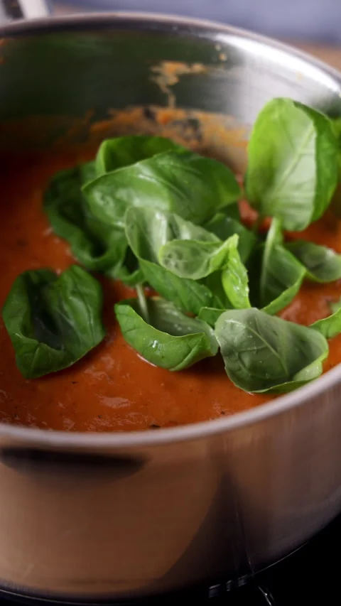 Adding Fresh Basil Leaves To Tomato Soup Close Up 스톡 동영상 332045913
