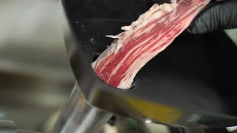 Adding fresh beef meat to grinding machine making minced meat, close up Stock Footage 229072736