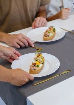 Adding fresh cherry tomatoes to healthy vegan sandwich Stock Photos