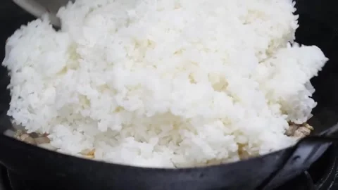 Adding Fresh Cooked Rice to Wok for Fried Rice Preparation Stock-Footage 347688772