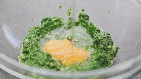 Adding fresh egg to mixture into a glass bowl. Stock Footage 159400730