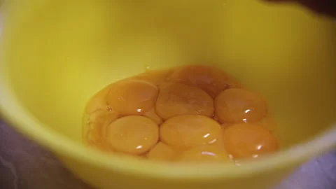 Adding Fresh Egg Yolks into a Yellow Bowl for Baking Vídeo Stock 332729345
