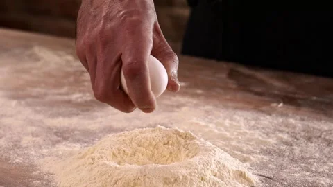 Adding fresh eggs to flour in process of makin dough Stock-Footage 148793215