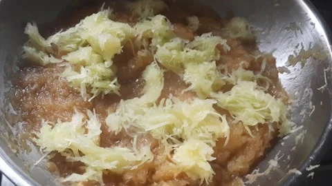 Adding Fresh Grated Mango to Cooking Mango Preserve on Stove Stock Footage 335758722