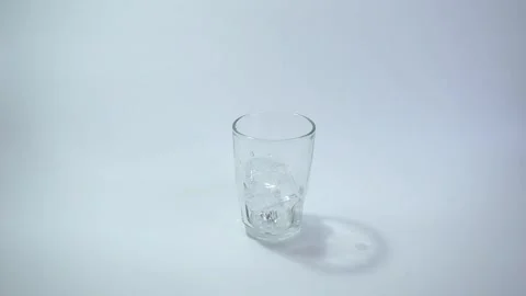 Adding Fresh Ice Cubes to an Empty Glass for a Cold Drink Stock Footage 281058152