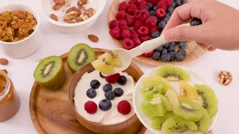 Adding Fresh Kiwi Slices to a Healthy Yogurt Breakfast Bowl Stock Footage 337771177