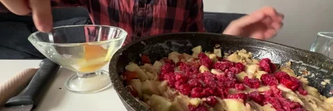 Adding fresh raspberries to apple mixture in baking dish Stock Footage 337482740