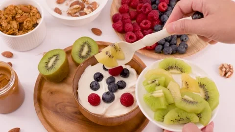 Adding Fresh Sliced Kiwi to a Healthy Yogurt Breakfast Bowl Stock Footage 337860394