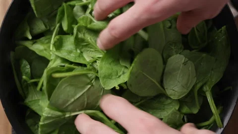 Adding Fresh Spinach Into Pan Close Up Top View Vídeos de archivo 337189895