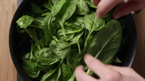 Adding Fresh Spinach Into Pan Top View Видео 337191679