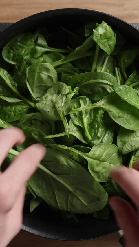 Adding Fresh Spinach Into Pan Top View Vertical Vidéo 337191808